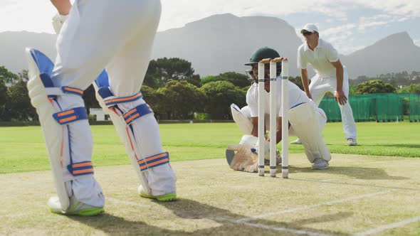 Cricket player catching the ball and destroying the stamps