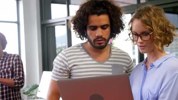 Business executives discussing over laptop in meeting