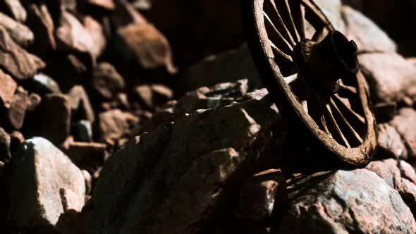 Old Wooden Wheel on Rocks alt