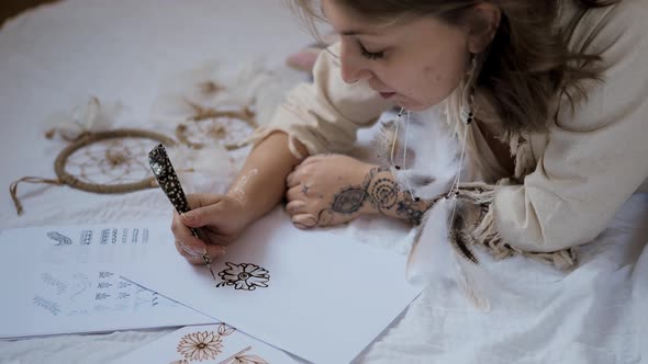 Young Woman Practice Henna or Mehndi Designs on Paper