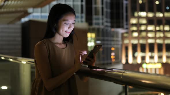 Woman use of smart phone in city at night 