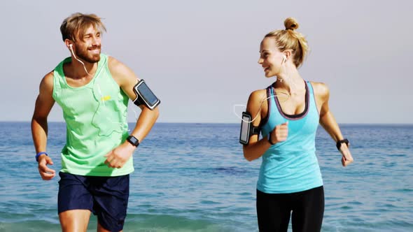 Smiling couple jogging on the beach