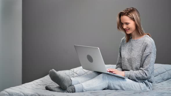 Happy Freelancer Woman Chatting Use Laptop Sitting on Comfortable Bed