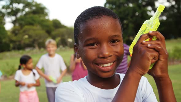 Portrait of smiling boy playing with water gun