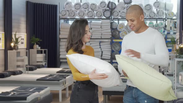 Lovely Couple Choosing New Pillows to Buy at Furnishings Store