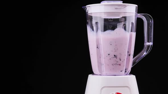 Blender Whisks Fruit Smoothie on Black Background in Slow Motion 200Fps