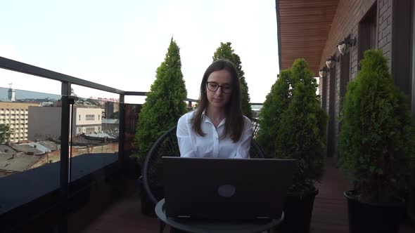 30s Caucasian Female Working From Home Using Laptop on a Terrace of Her House