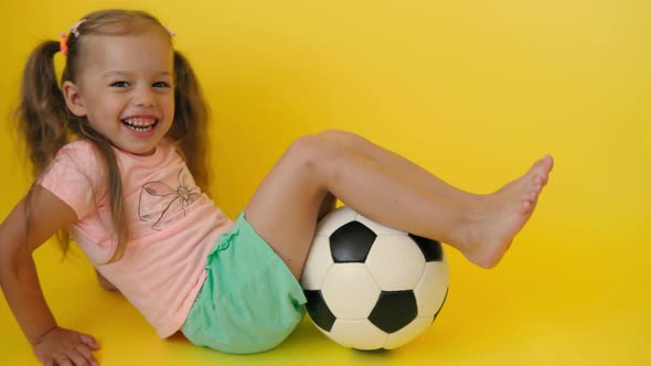 Authentic Cute Smiling Preschool Little Girl with Classic Black and White Soccer Ball Look at Camera