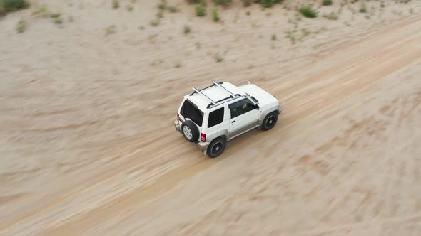 Aerial View of a Car Driving on Sand