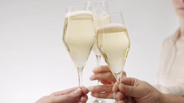 Three Glasses of Champagne Approach Collide on a White Background