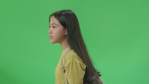 Side View Of Asian Girl Student Walking To School On Green Screen Chroma Key