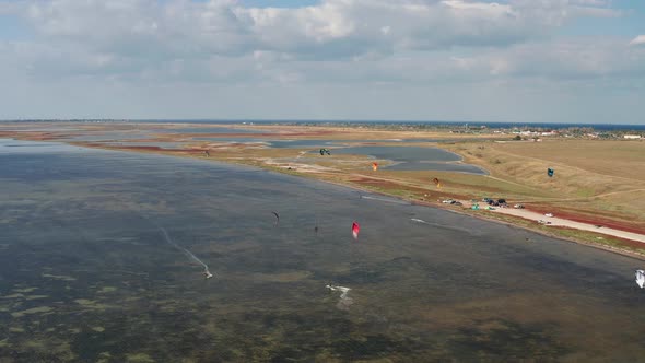 People go kitesurfing on the sea. The wind carries the athlete along the sea waves.