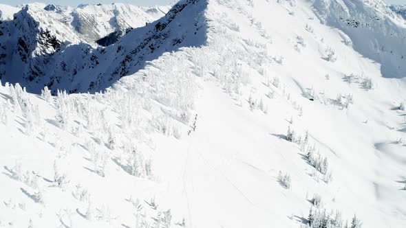 Skiers walking on a snow capped mountain 4k