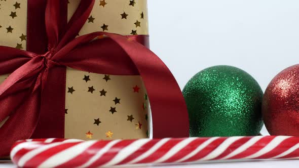 Christmas gift composition with red bow, Christmas tree balls and caramel cane.