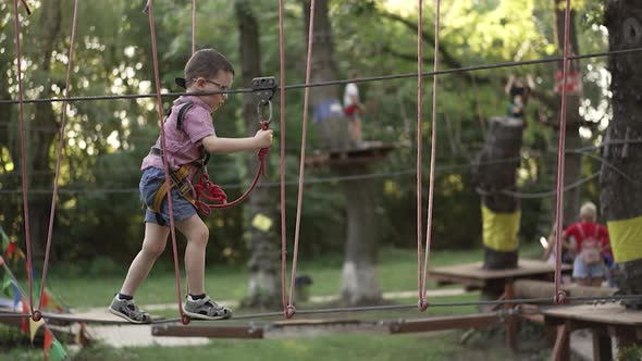 Child Walks on a Rope Bridge in the Park