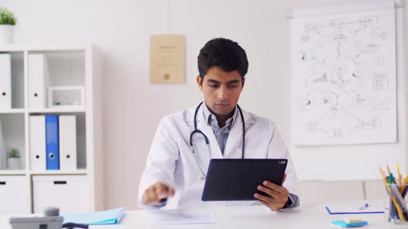 Doctor with Tablet Pc and Papers at Hospital