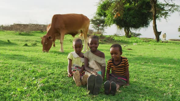 Maasai children sitting on the grass alt