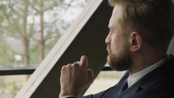 Close Up of Businessman Sitting on Couches Discussing with His Colleague