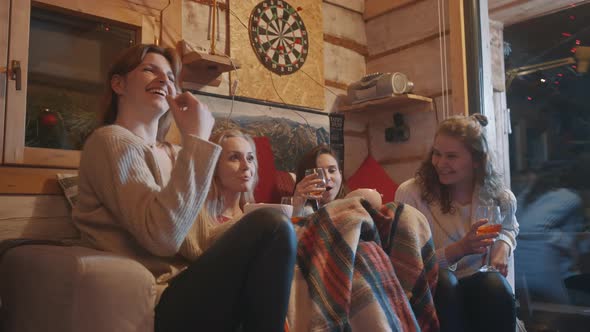 Female Best Friends Spending Winter Holidays in the Cozy Home Drinking Mulled Wine and Having Snacks