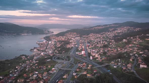 Aerial view of the AP9 highway at colorful sunset in evening traffic and the suspension bridge over