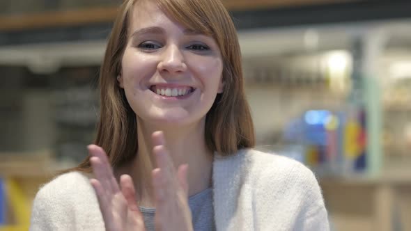 Applauding Headshot of Happy Young Woman Clapping in Cafe