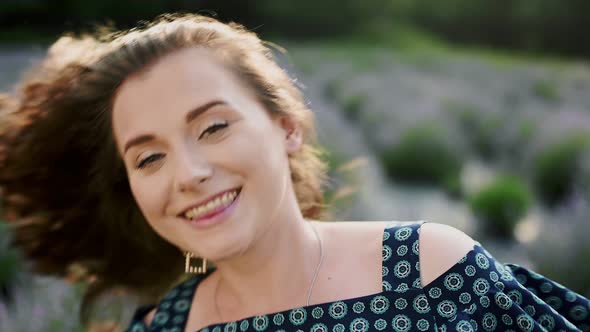 Portrait of Pretty Young Caucasian Woman Walking on Lavander Field Posing on Camera with Lovely