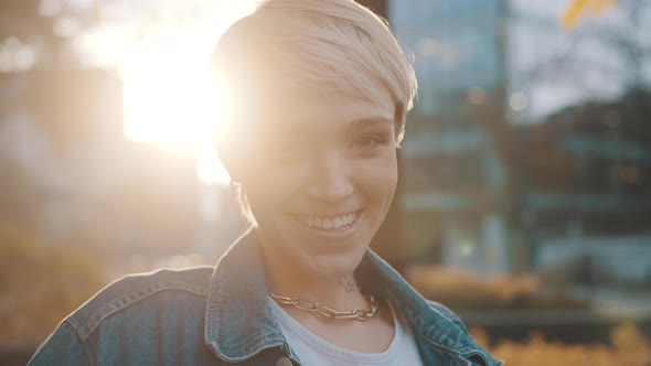 Portrait of Young Blonde Woman Laughing and Lifting Usa Flag in the Park in Autumn During Sunset