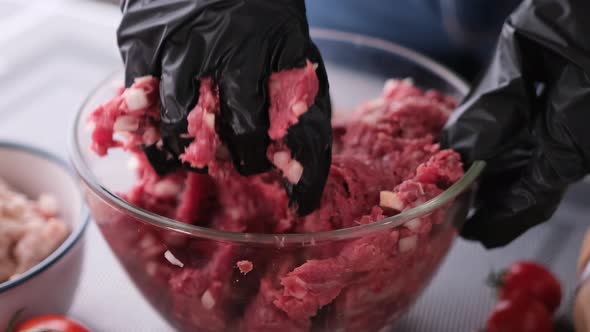 Kneading of Minced Meat with Onion and Spices in a Glass Bowl