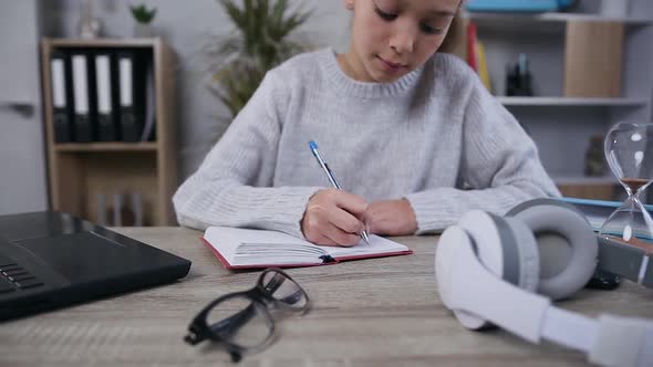 15-Aged Schoolgirl in Gray Knitted Sweater which Writing Out from Laptop the Notes into Her Diary