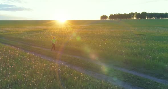 Sporty Child Runs Through a Green Wheat Field