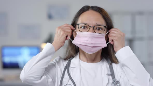 Female Doctor Putting On Mask