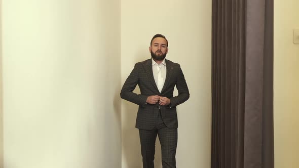 Stylish Young Man In Fitting Room Trying On New Suit.