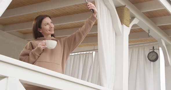 Woman Having A Cup Of Coffee And Making Selfie Standing On A Terrasse Shot On Red Camera