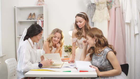 Group of Young Models with Friendly Designer of Wedding Dresses