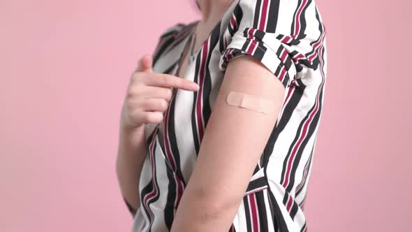 Young Woman Showing COVID19 Vaccine Bandage Merrily