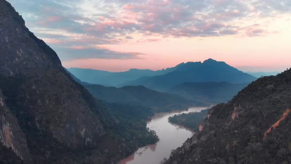 Aerial: flying over Nam Ou River Nong Khiaw Muang Ngoi Laos, sunset dramatic sky