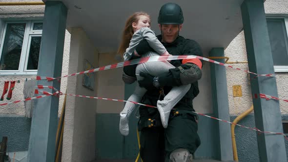 Lifeguard man will push a little girl child in his arms from the doorway of a burning house