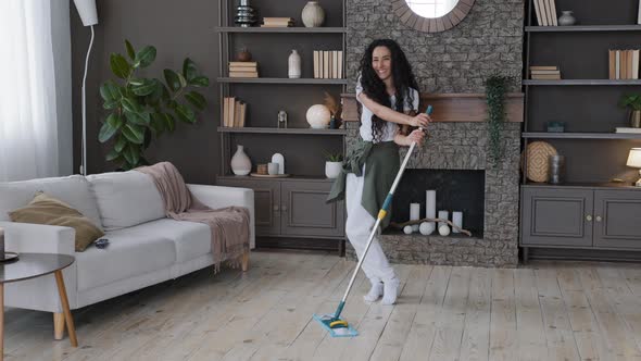 Young Cheerful Woman Cleaning Apartment Washes Floor in Living Room Excited Energetic Girl Dancing