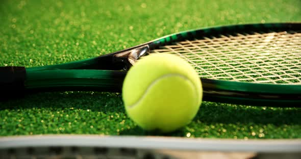 Close-up of tennis ball and rackets arranged on grass 4k