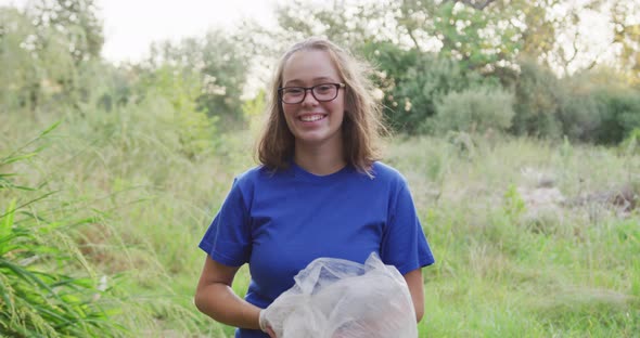 Caucasian woman smiling and looking at camera during river clean-up day