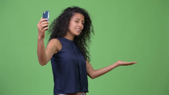 Young Beautiful Hispanic Businesswoman Showing Phone
