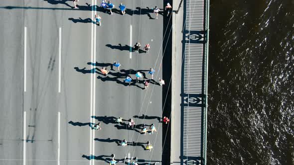 Sporty People Run Summer Marathon Along Huge Grey Bridge