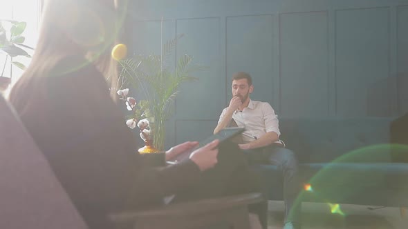 Female Psychologist Listening To the Man Client Sitting During Psychological Session in the Blue