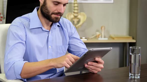 Male therapist using digital tablet