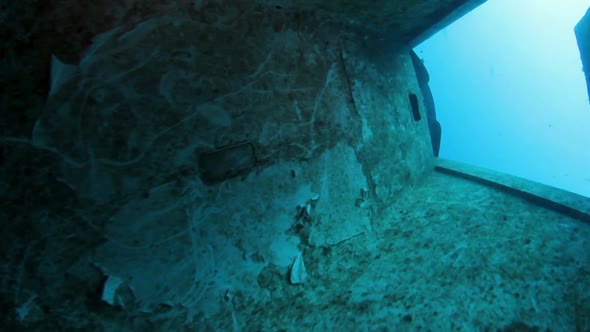 A scuba diver slowly exits a sunken plan wreck deep in the Pacific Ocean