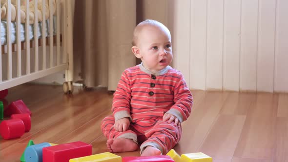 Little Baby Clapping His Hands Playing with Educational Colorful Toys at Home Sitting on Floor