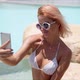Smiling Woman in Swimwear Taking Selfie on Smartphone Showing Two Fingers - VideoHive Item for Sale