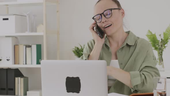 Happy Young Lady Between 30 and 40 Years Old is Speaking on Phone