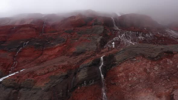 Close up showing a large waterfalls from meltwater with the gletser in the background 