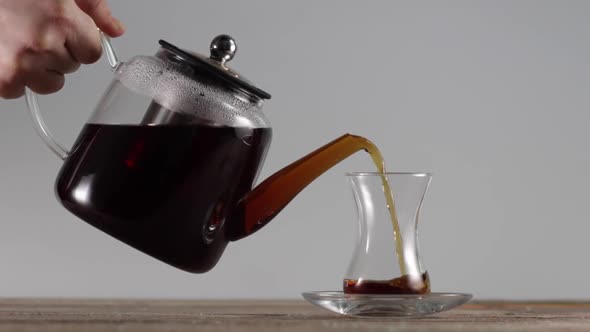 Pouring Tea From a Kettle in a Cup